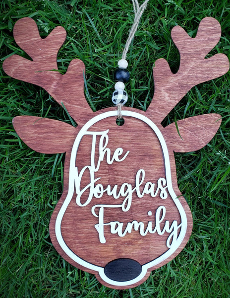  Create a unique, custom accent for your holiday decorations with this personalized 8.5" x 10.5" Reindeer Family Name Sign. Laser cut from Birch wood, stained with a mixture of cherry and maple, and hand-painted with acrylic and chalk paints, it's the perfect complement to your front door or wreath. Add your family name and choose a black or red nose. Ready to ship in 5-7 days. 