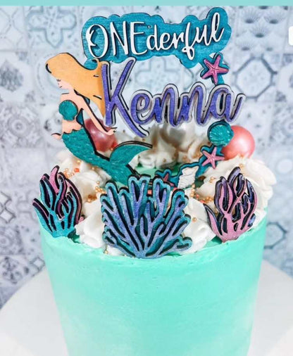 Make your event one-derful and take it under the sea with these personalized cake toppers! Add a splash of coral, starfish, sea shells and a mer-mazing mermaid, perfect for an aquatic theme party. With a little imagination, making a splash is easier than ever!