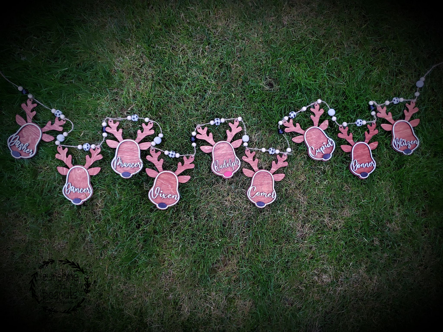 Our Reindeer Garland/Banner is a must-have for your holiday decorations! Featuring nine of Santa's famous reindeer - Dasher, Dancer, Prancer, Vixen, Comet, Cupid, Donner, Blitzen and Rudolph - this 6.5' garland includes black, white, and buffalo check beads on a jute strand. Crafted with birch wood and stained in cherry and maple, this garland will bring festive cheer to any home. Order yours today and complete the set with our Reindeer ornaments and Wreath Sign!