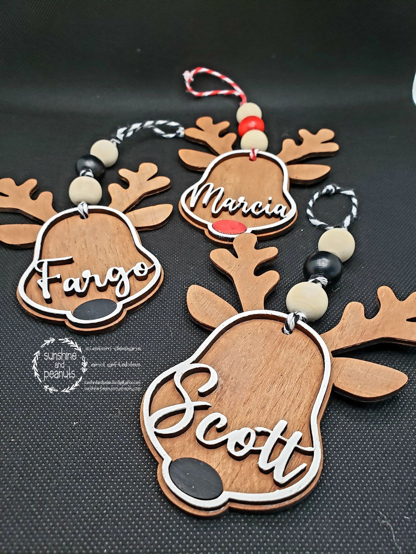 This personalized reindeer ornament is the perfect addition to your holiday décor. Laser cut from Birch wood, it is stained with a unique combination of cherry and maple wood, with hand-painted accents. Measuring 4" wide and 5" tall, it comes with a choice of either a Black or Red nose and can be personalized with your name. Each ornament is made to order and will ship within 5-7 days.